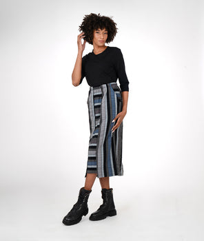 model in a black teeshirt with a multicolored stiped skirt with a contrasting center panel