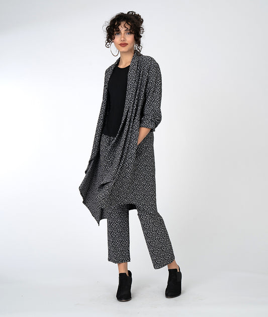 model in a black and grey leaf print straight leg pant, with a matching duster cardigan and a black tee