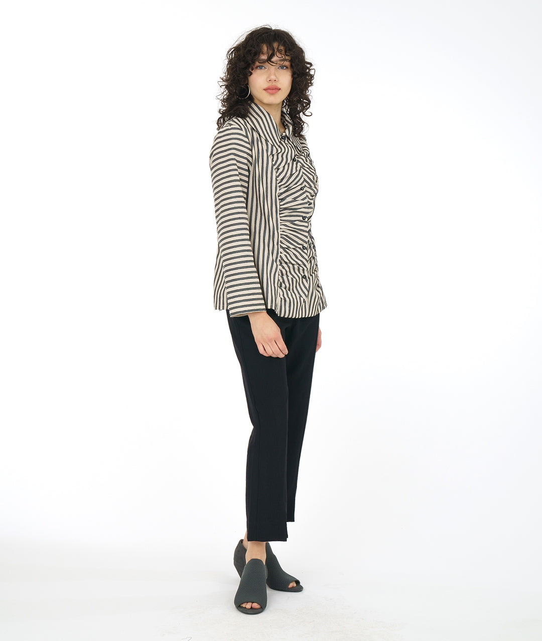 model in a slim black pant with a taupe and black striped blouse with a gathered detail up the center front along princess seams