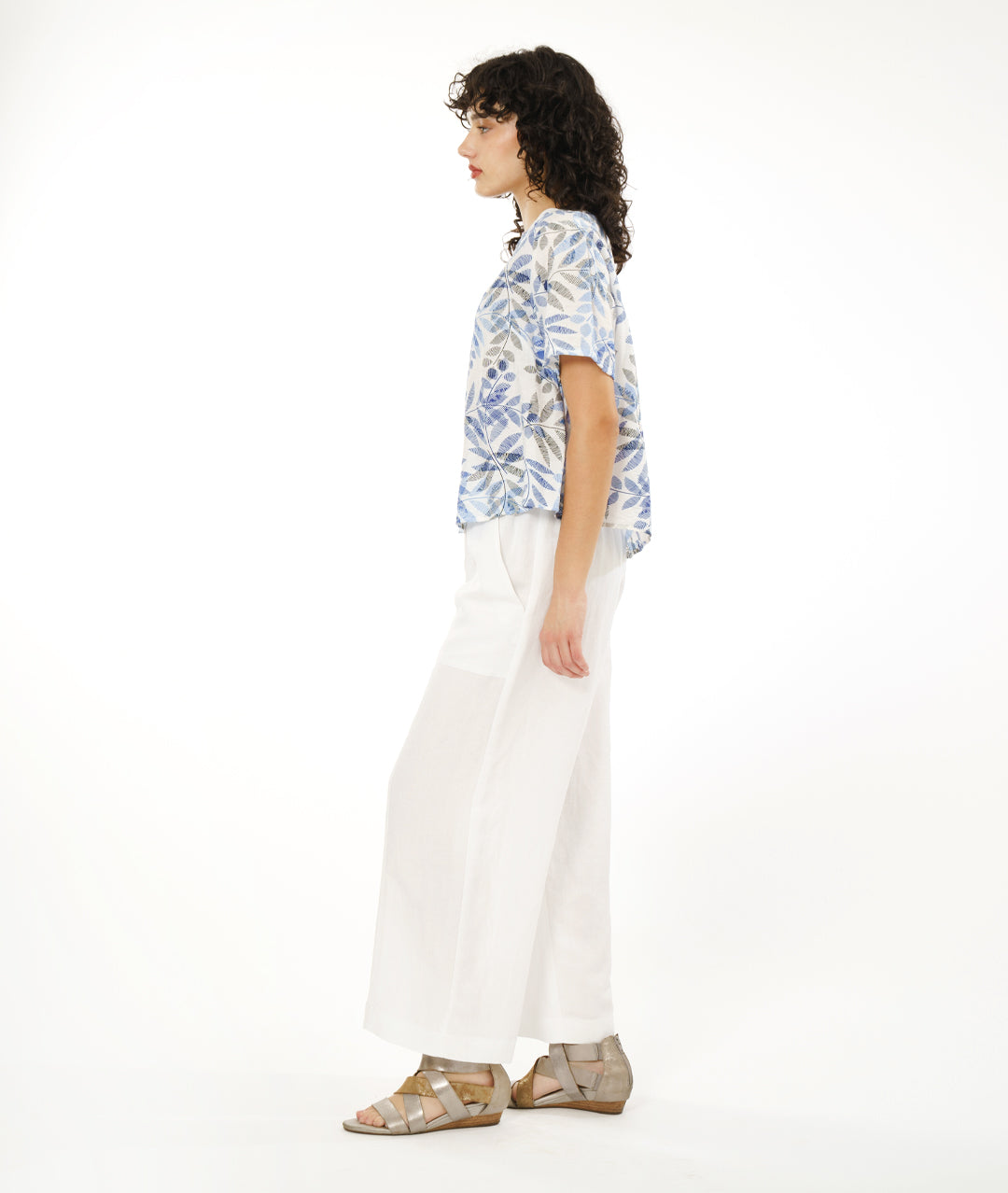 model in a wide white pant with a boxy pullover tee in white, with a blue and black leaf print