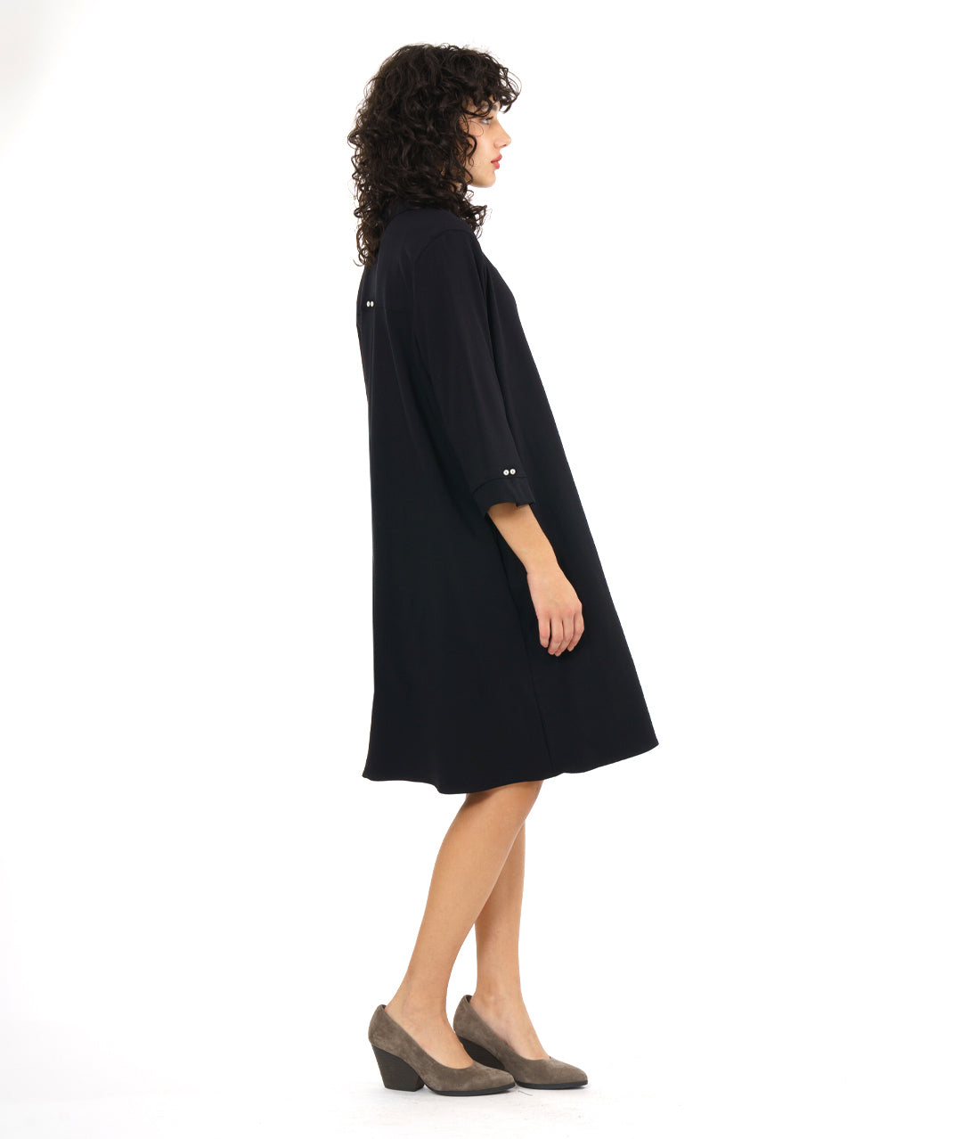 model in a black, knee length button down shirt dress with 3/4 sleeves and a twin button detail