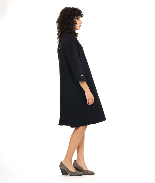 model in a black, knee length button down shirt dress with 3/4 sleeves and a twin button detail