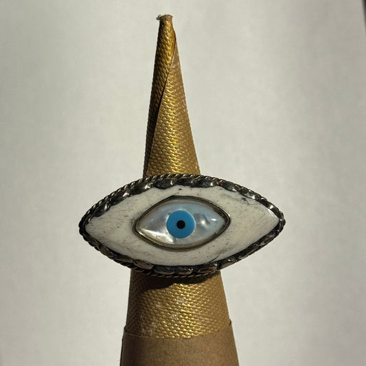 eye design ring on a ring holder cone against a white background
