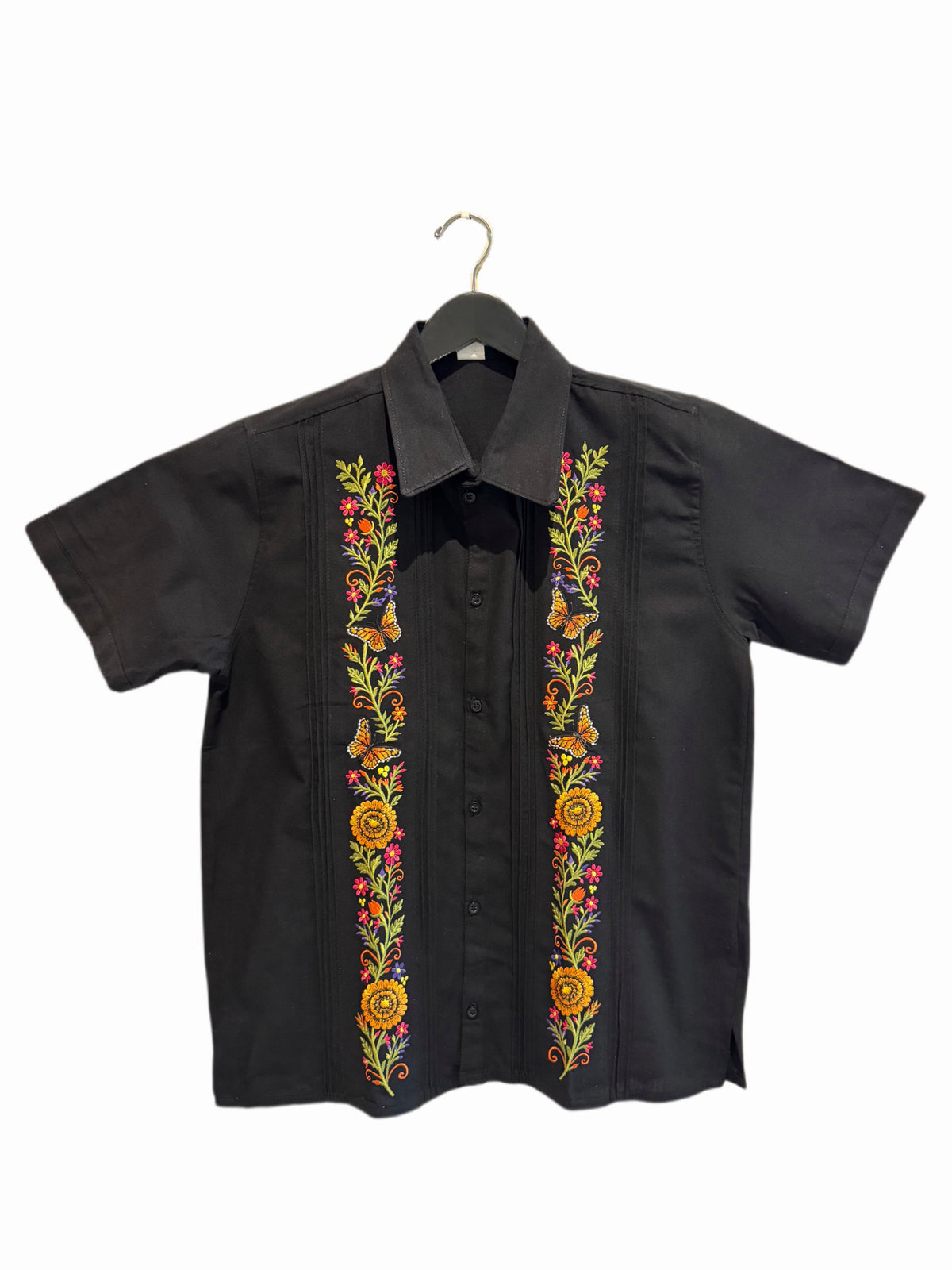 A black short-sleeve button-up shirt hanging on a black hanger, featuring vibrant multicolor floral embroidery running down both front panels.