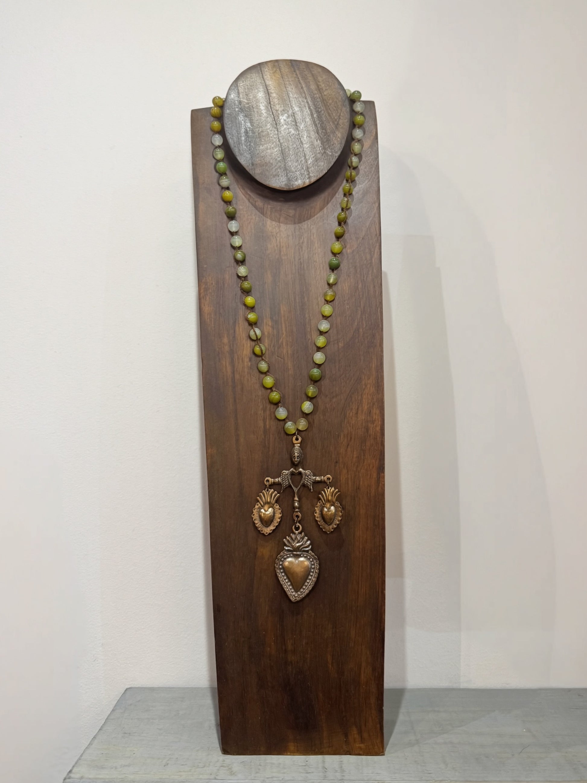 Necklace with yalalag pendant on a wooden stand against a white background