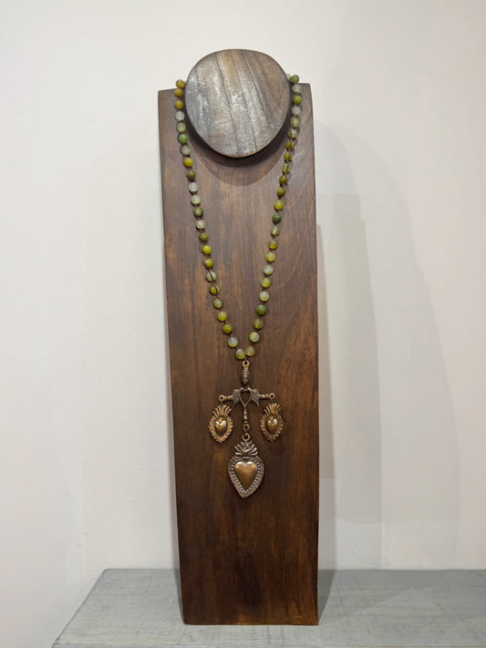 Necklace with yalalag pendant on a wooden stand against a white background