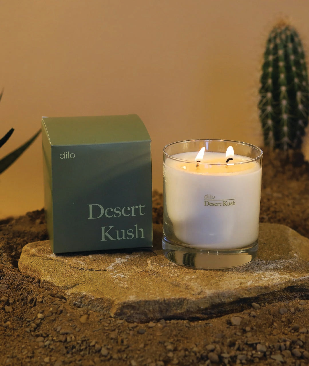 desert kush scented candle with packaging on rock and desert background