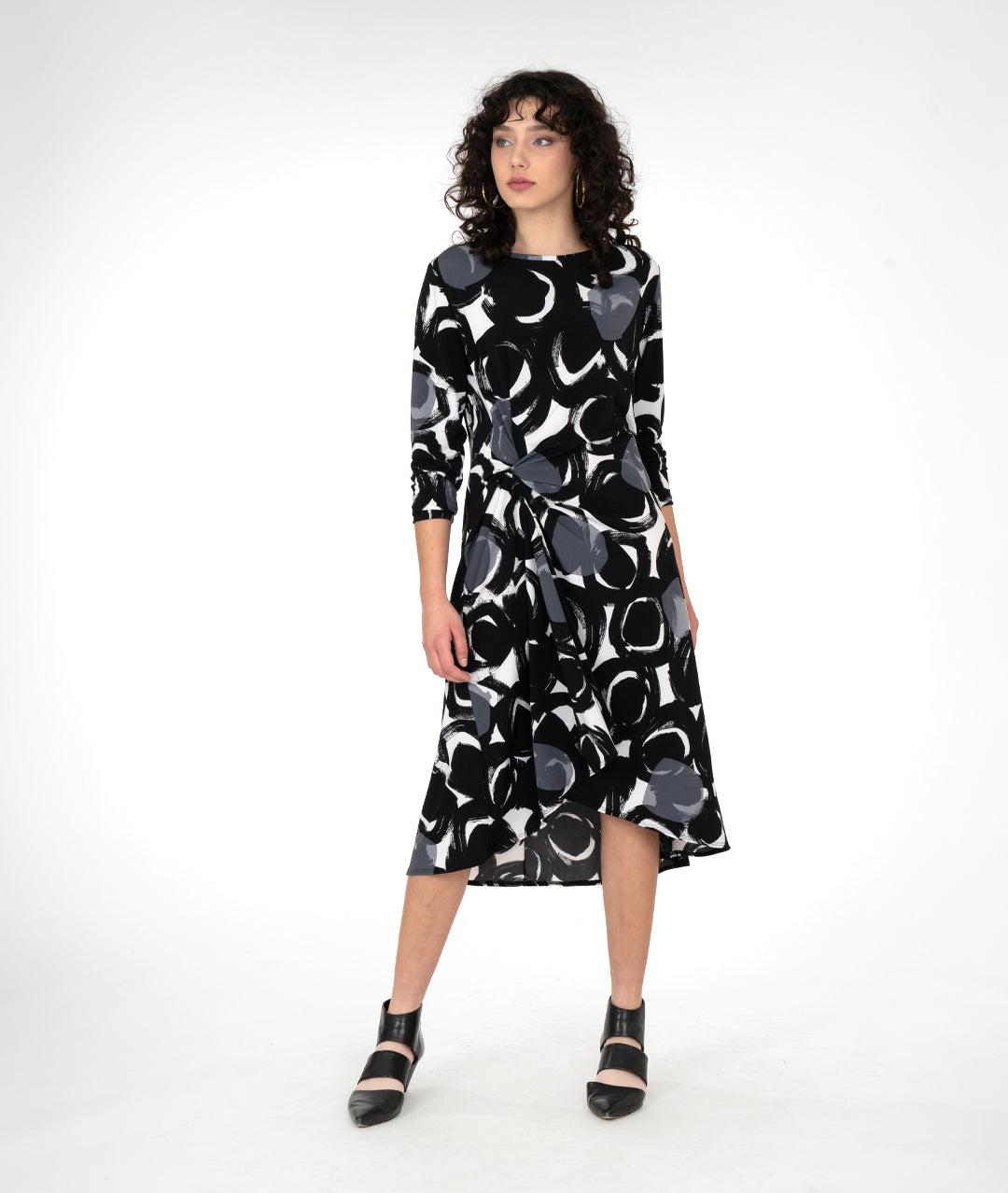 model in a black, white and grey circle print dress with a knot detail on one hip