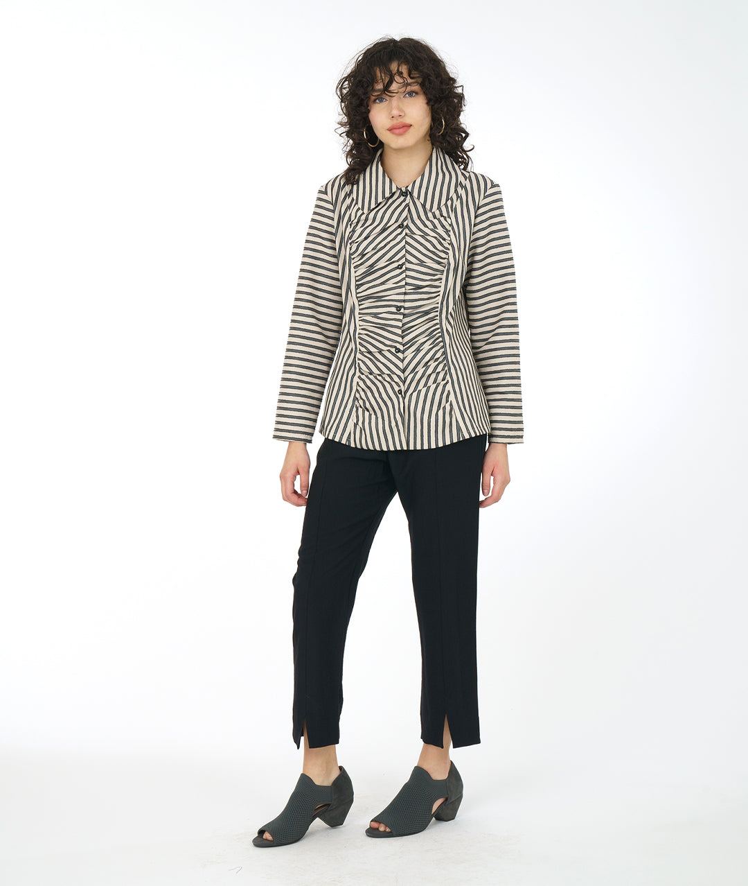 model in a slim black pant with a taupe and black striped blouse with a gathered detail up the center front along princess seams