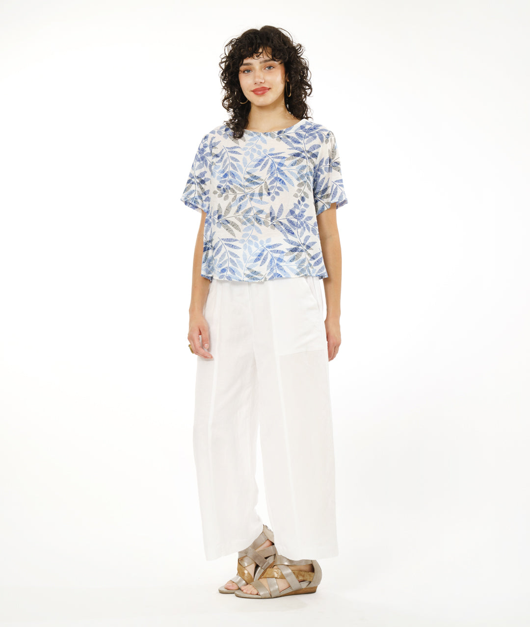 model in a wide white pant with a boxy pullover tee in white, with a blue and black leaf print