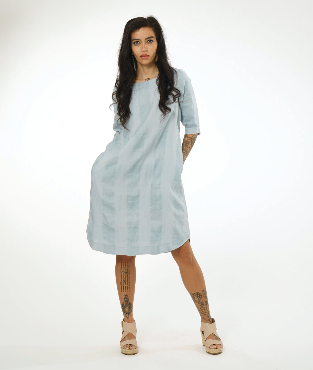 model in a silvery blue extra large check print pullover dress with a rounded neckline, elbow length sleeves and a rounded hemline 