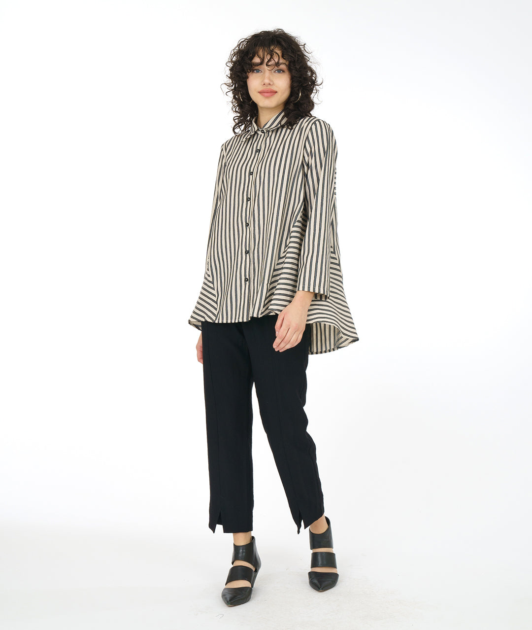 model in a slim black pant with a taupe and black striped blouse with a panel adding body on either side