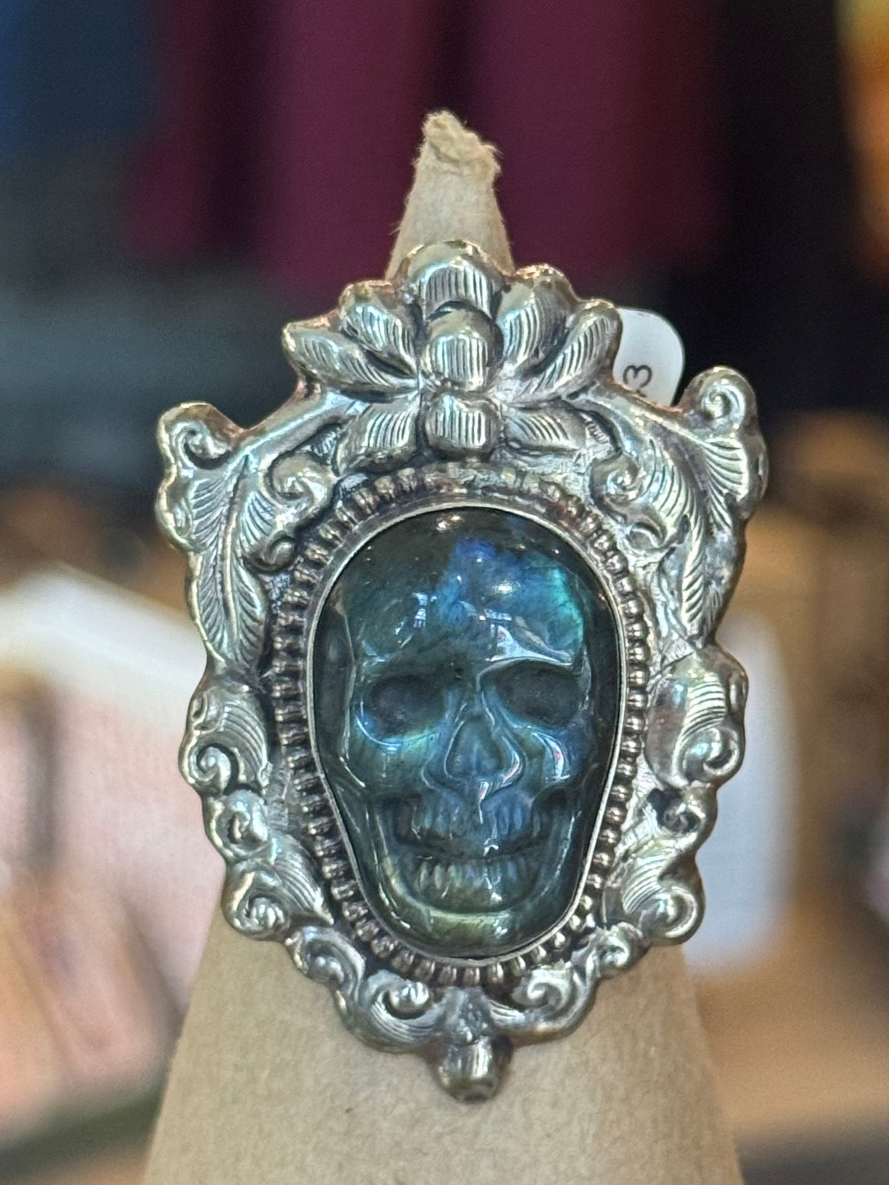 Silver ring with skull design on a neutral background