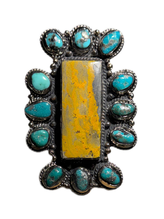 Bumblebee jasper stone with turquoise stone surrounding ring on a white background