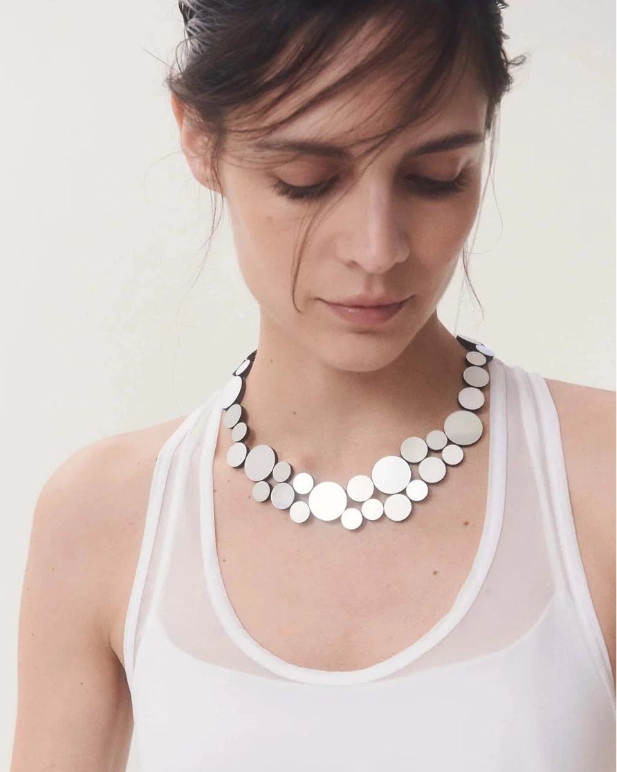 model wearing silver circle cluster necklace against white background