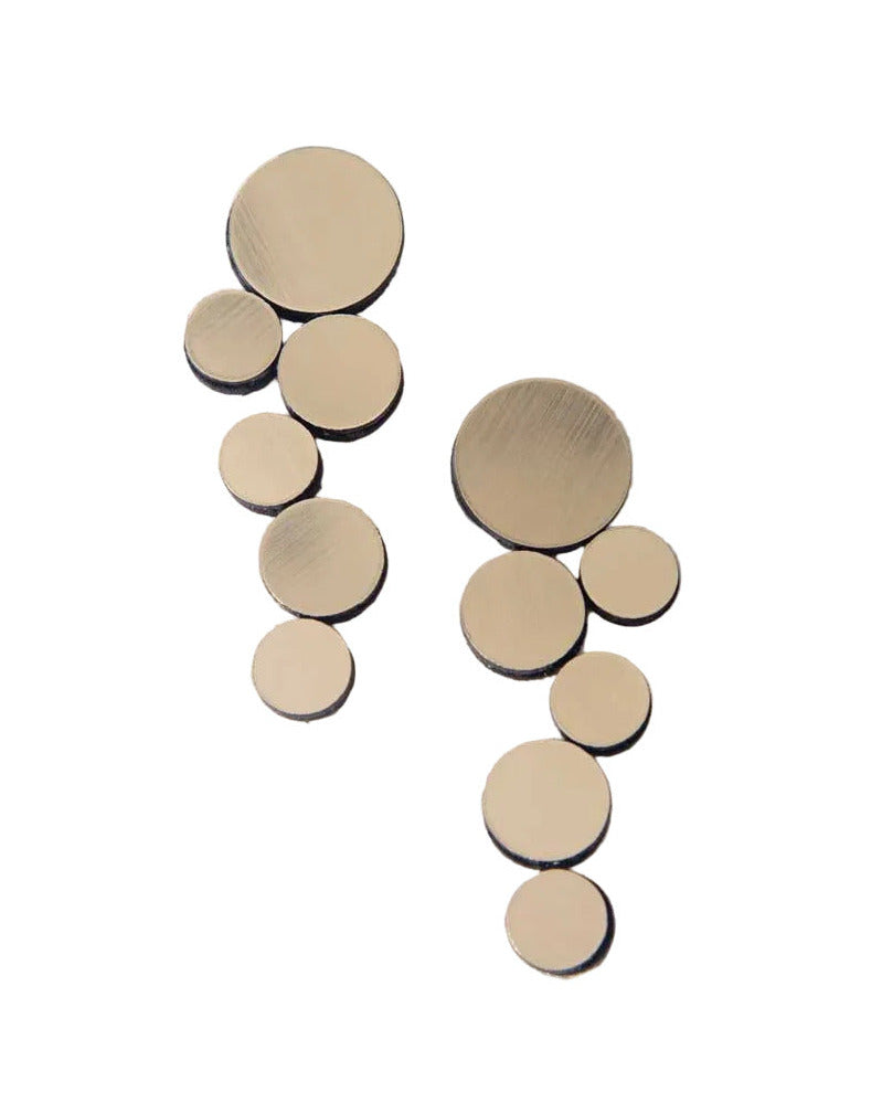 Gold circle cluster earrings against white background