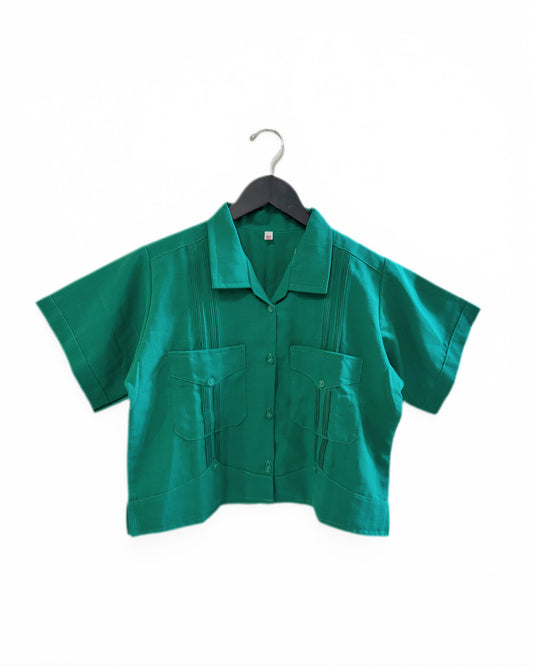 Green shirt on a hanger against a white background