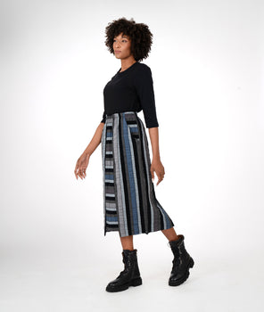 model in a black teeshirt with a multicolored stiped skirt with a contrasting center panel