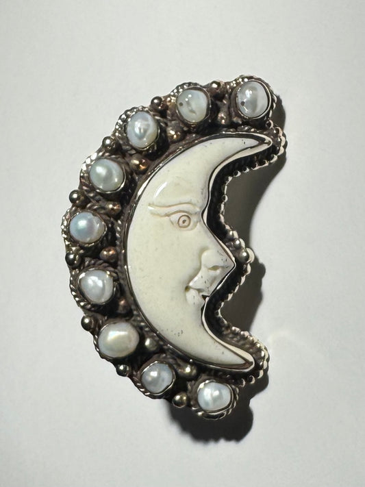 A silver-colored adjustable ring featuring a bone moon design with pearl accents.