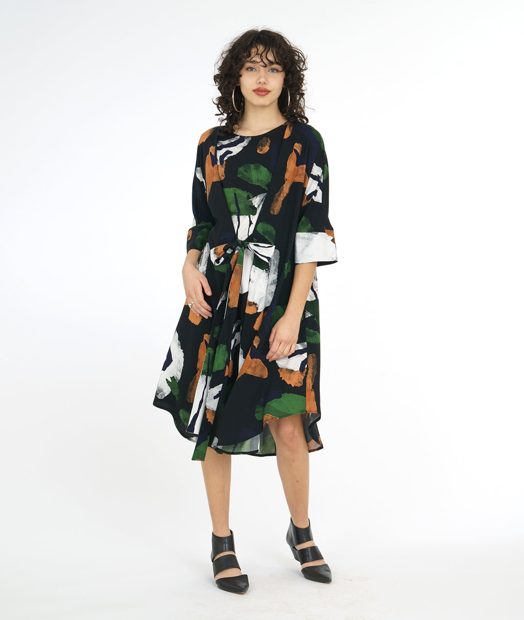 model in a black and multi color brush stroke print dress with a kimono style sleeve and a center waist tie belt that can be worn in a number of ways