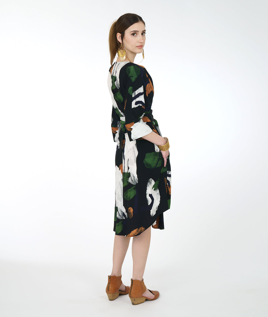 model in a black and multi color brush stroke print dress with a kimono style sleeve and a center waist tie belt that can be worn in a number of ways