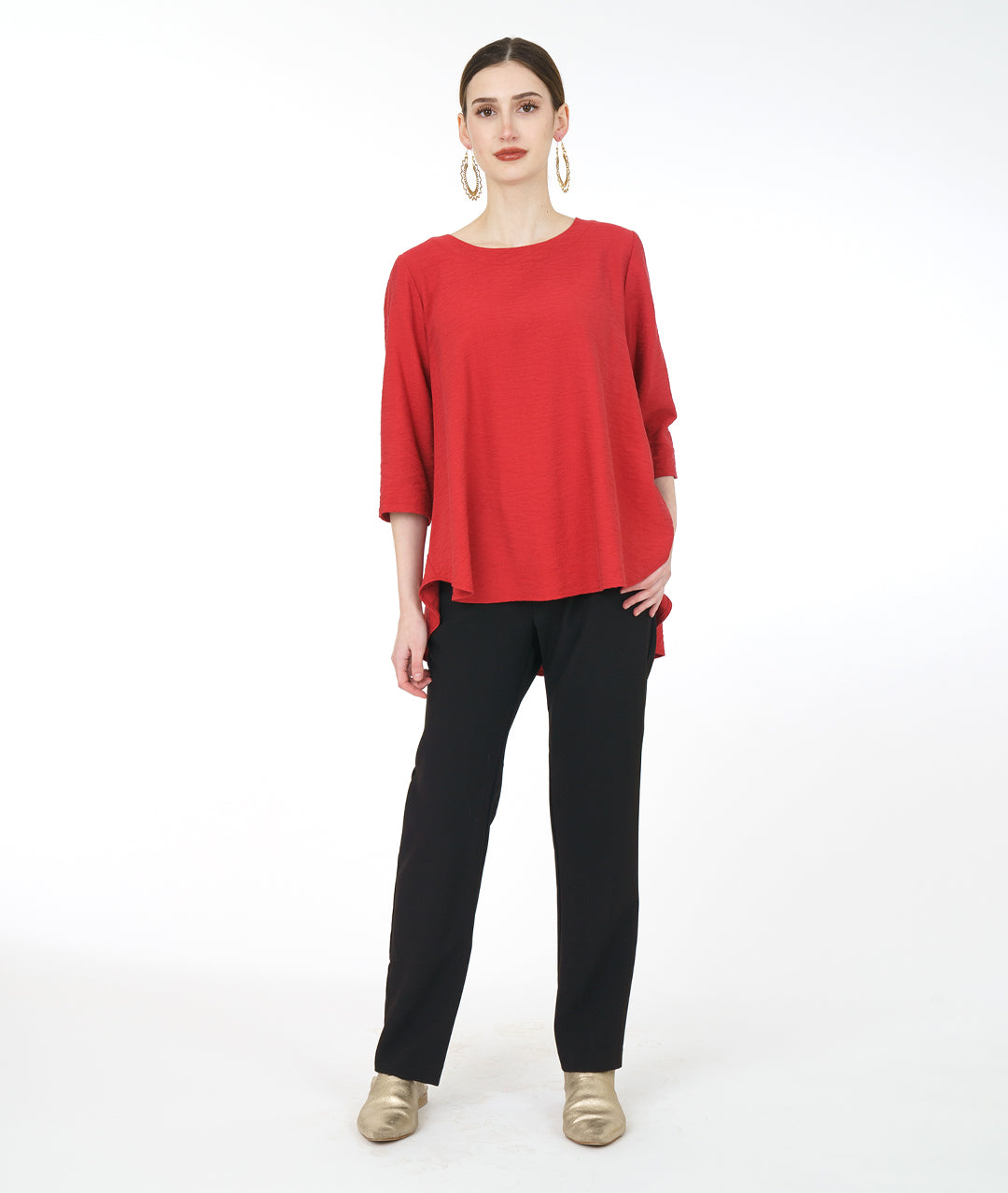 model in a slim black pant with a red pullover top with 3/4 sleeves and a swingy back
