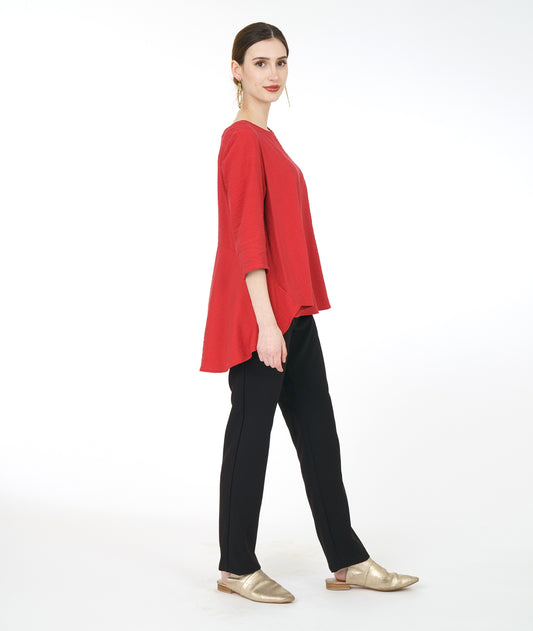 model in a slim black pant with a red pullover top with 3/4 sleeves and a swingy back