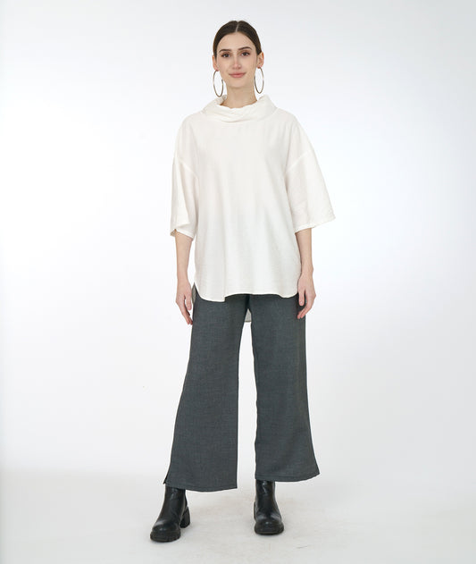 model in a wide leg grey pant with a white cowl neck top with a drop shoulder
