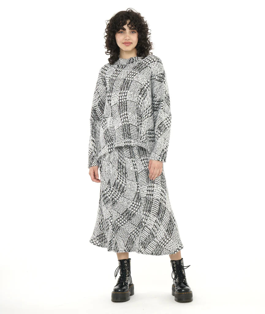 model wearing black and white pattern top and skirt with black boots