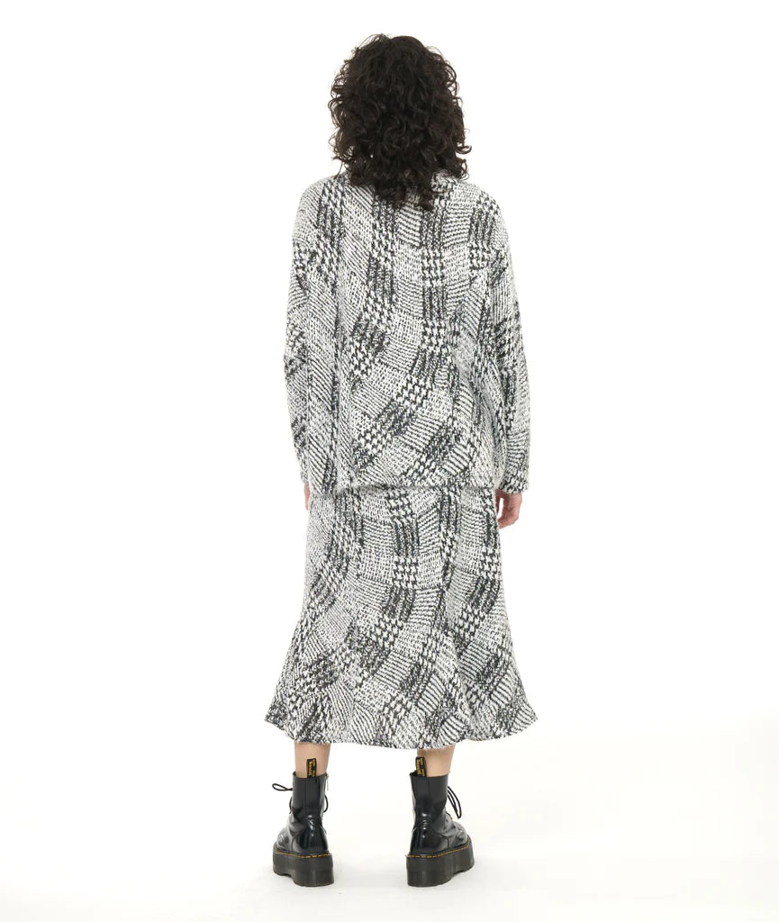 model showing back of black and white pattern top and skirt with black boots