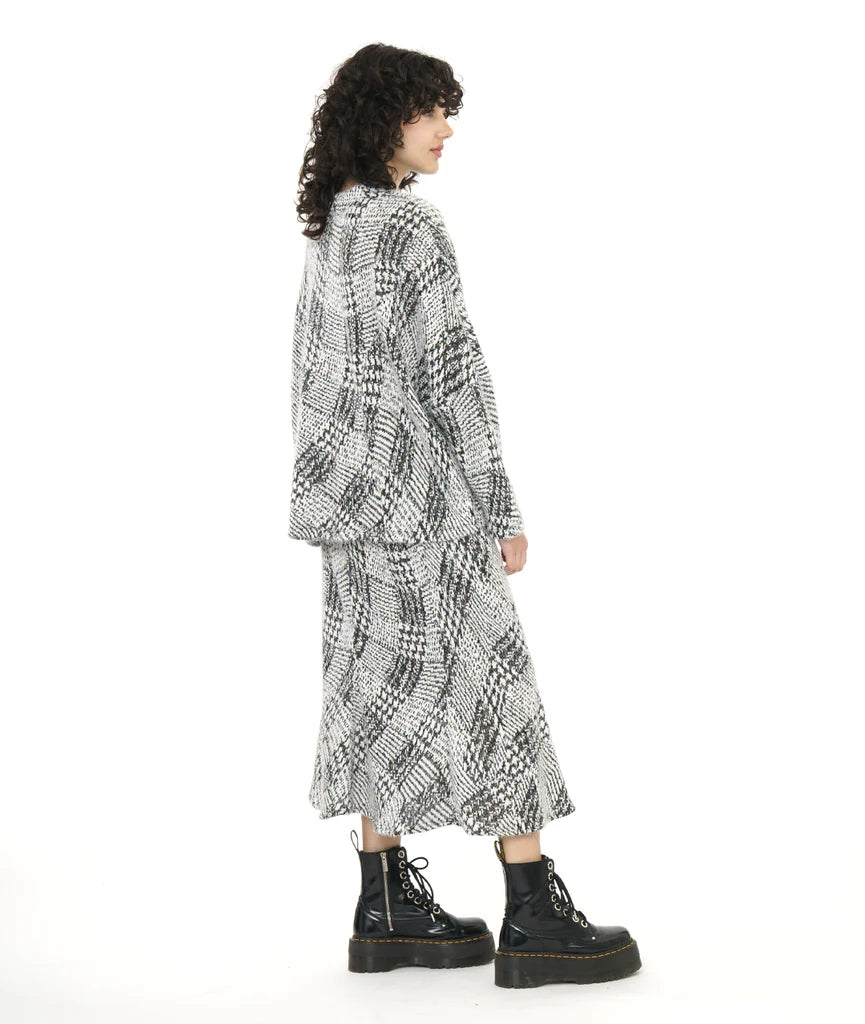 model wearing black and white pattern top and skirt with black boots