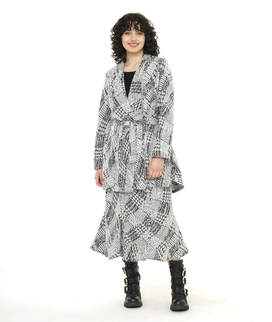 model wearing black and white pattern top and skirt with black boots