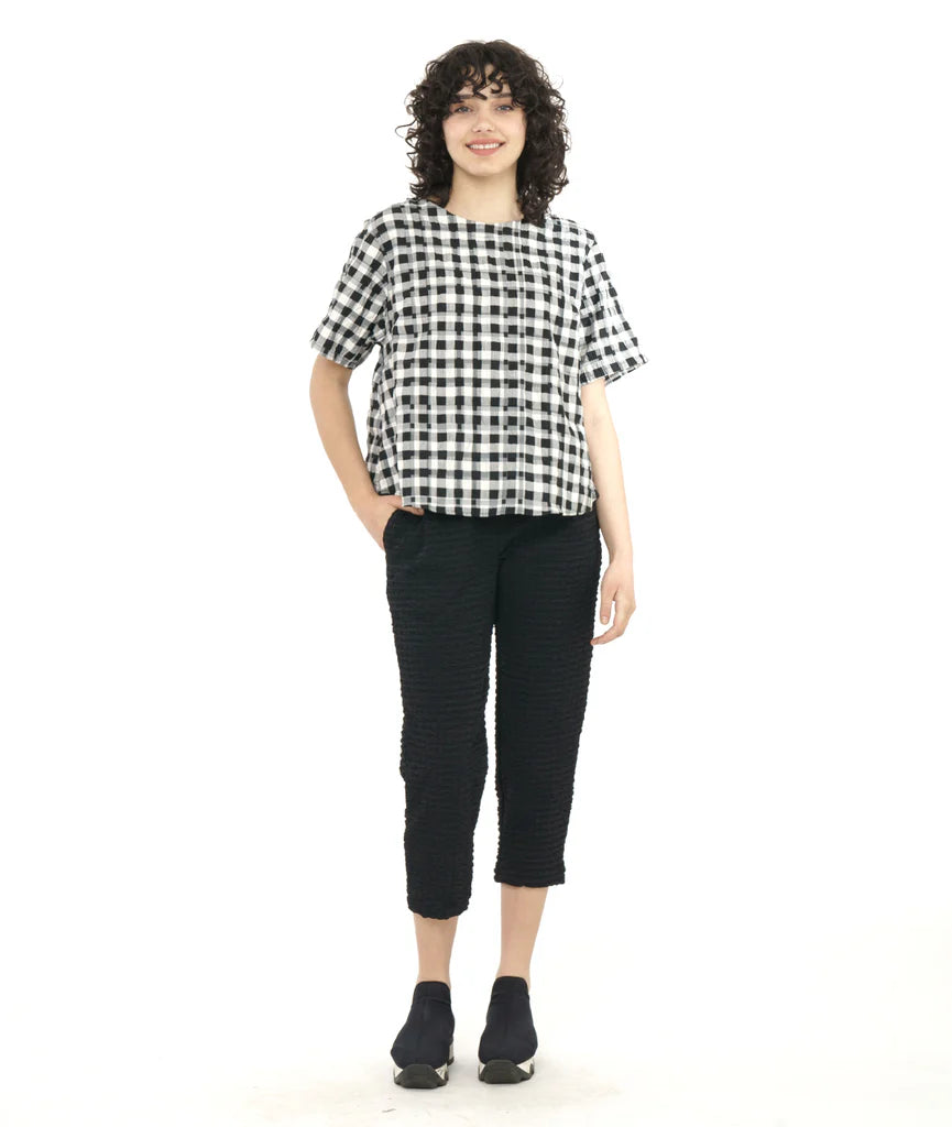 model wearing plaid boxy top with cropped black pants and sneakers