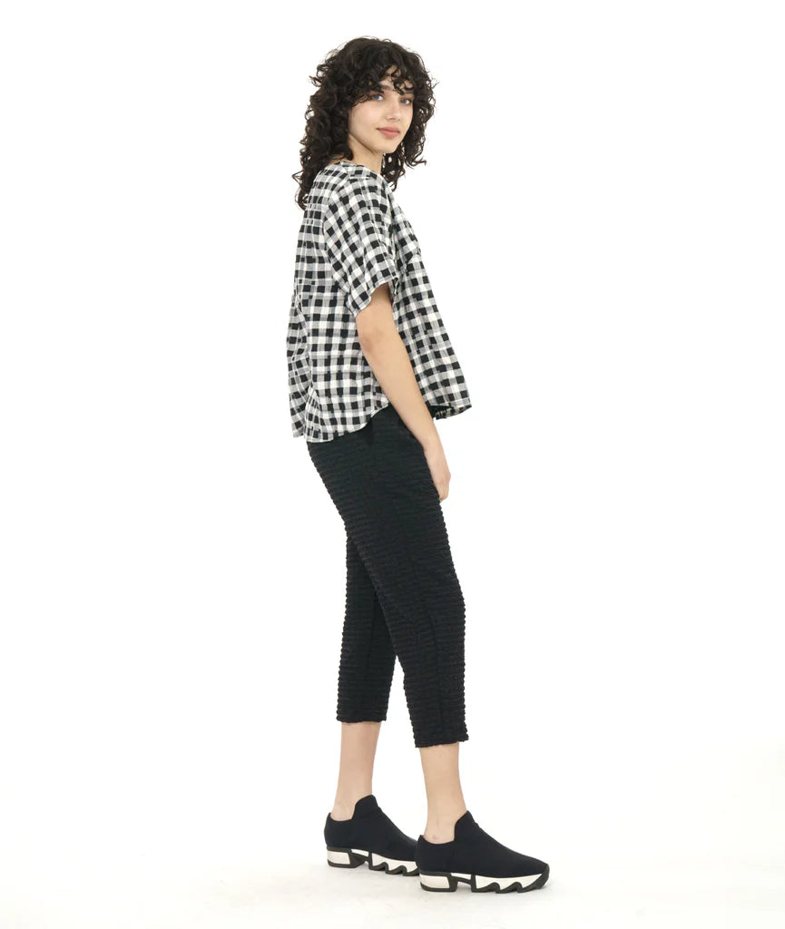 model wearing plaid boxy top with cropped black pants and sneakers