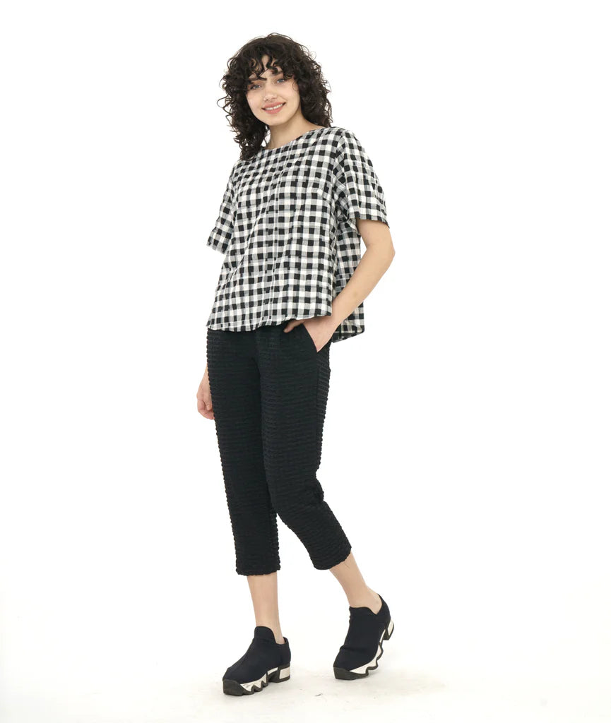 model wearing plaid boxy top with cropped black pants and sneakers