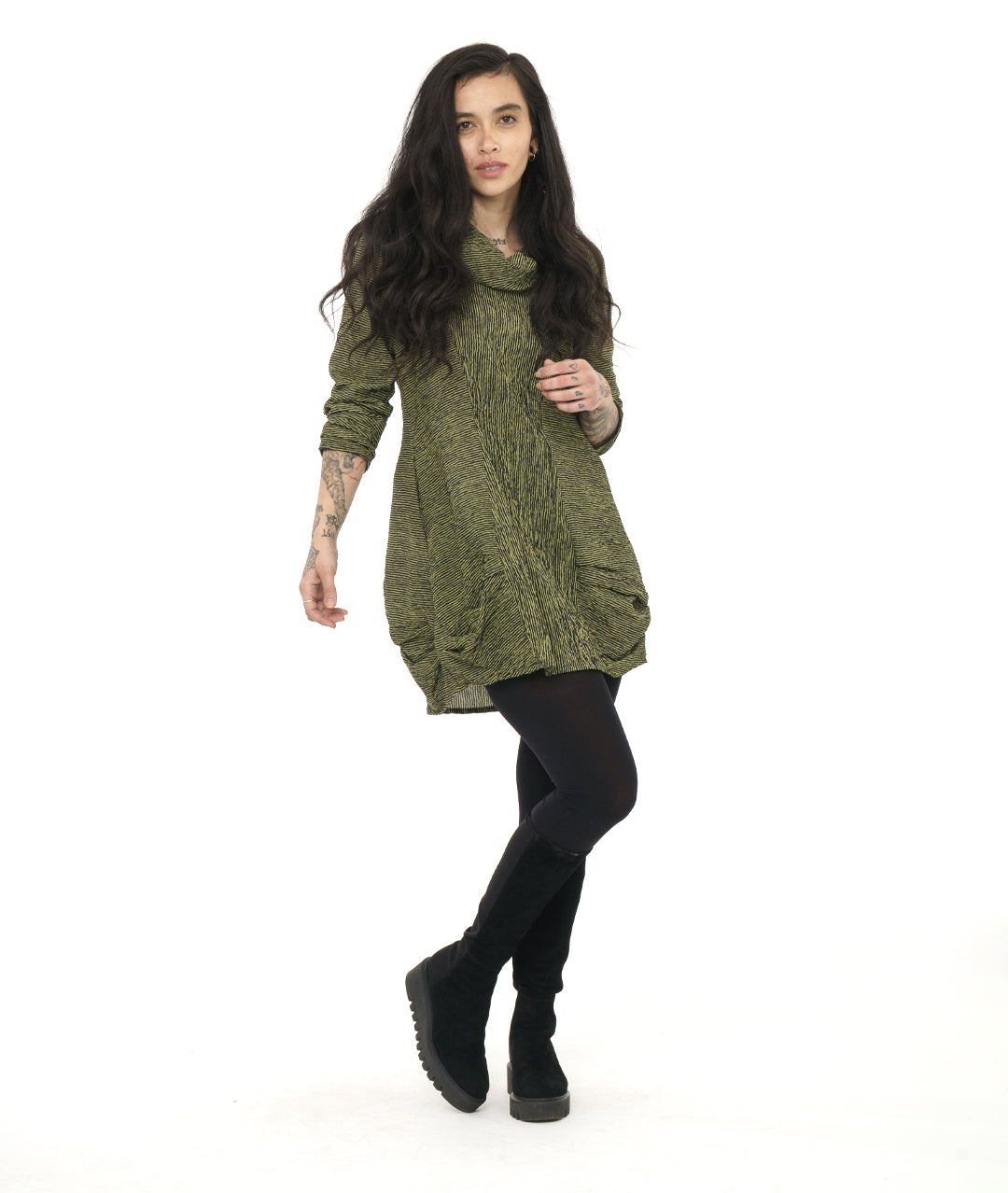 model in a green and black striped tunic with princess seams, a large cowl neck, long sleeves and pleating at the hips