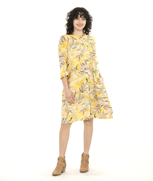 model in a yellow leaf print shirt dress with 3/4 sleeves and side seam pockets