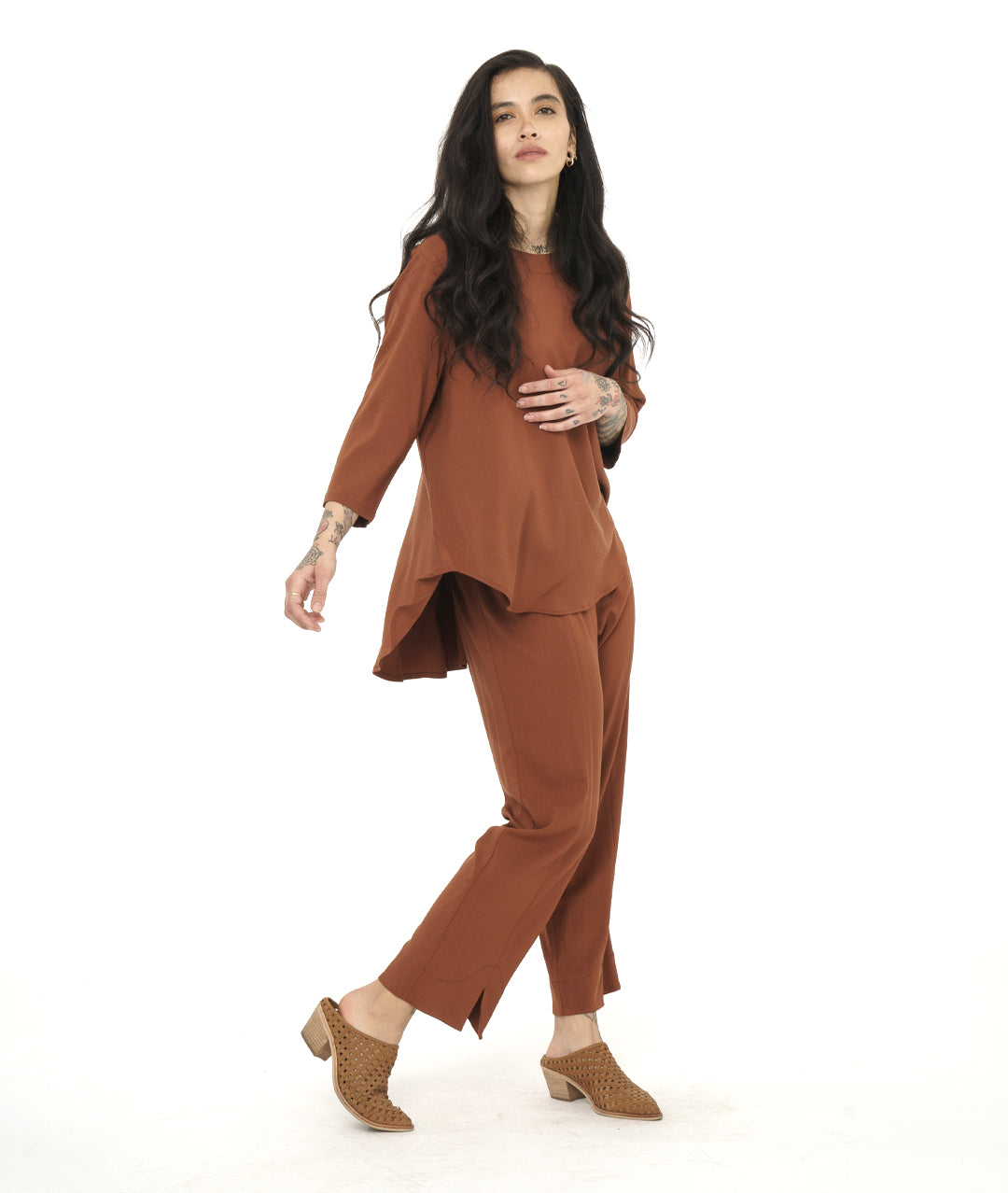 model in a rust color pullover top with a matching straight leg pant with a split at the center front hem