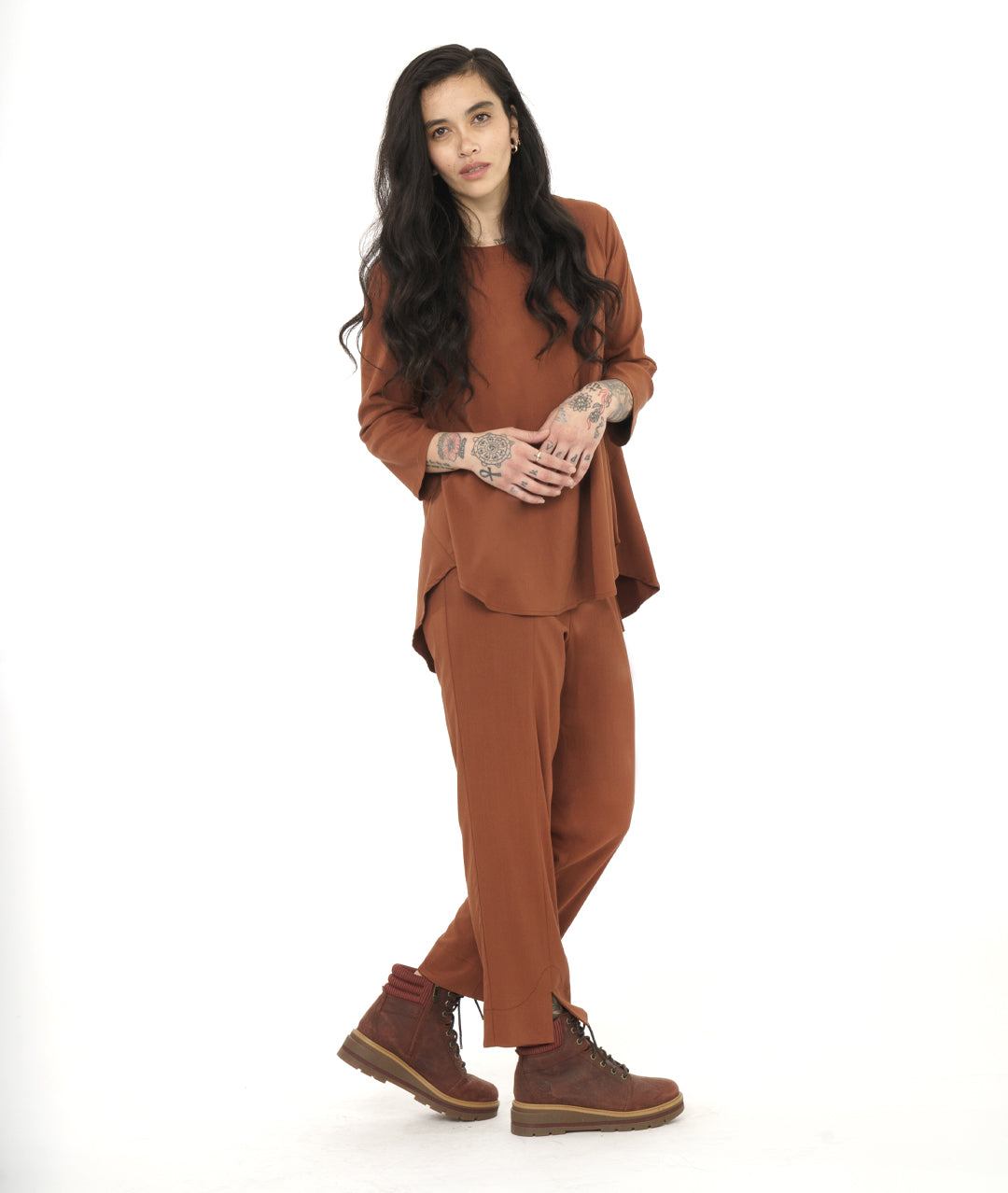 model in a rust color pullover top with a matching straight leg pant with a split at the center front hem