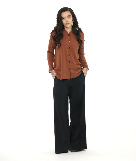 model in a wide leg black pant, worn with a rust color button down blouse 