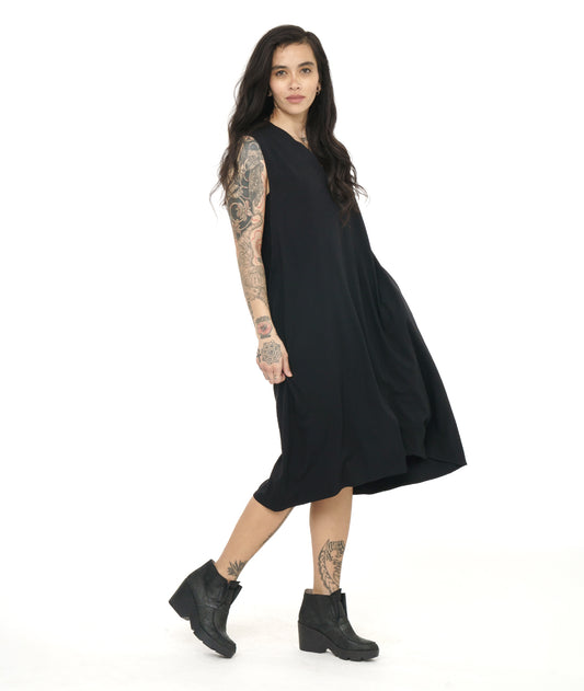 model in a black sleeveless dress with a v-neck and a center front seam