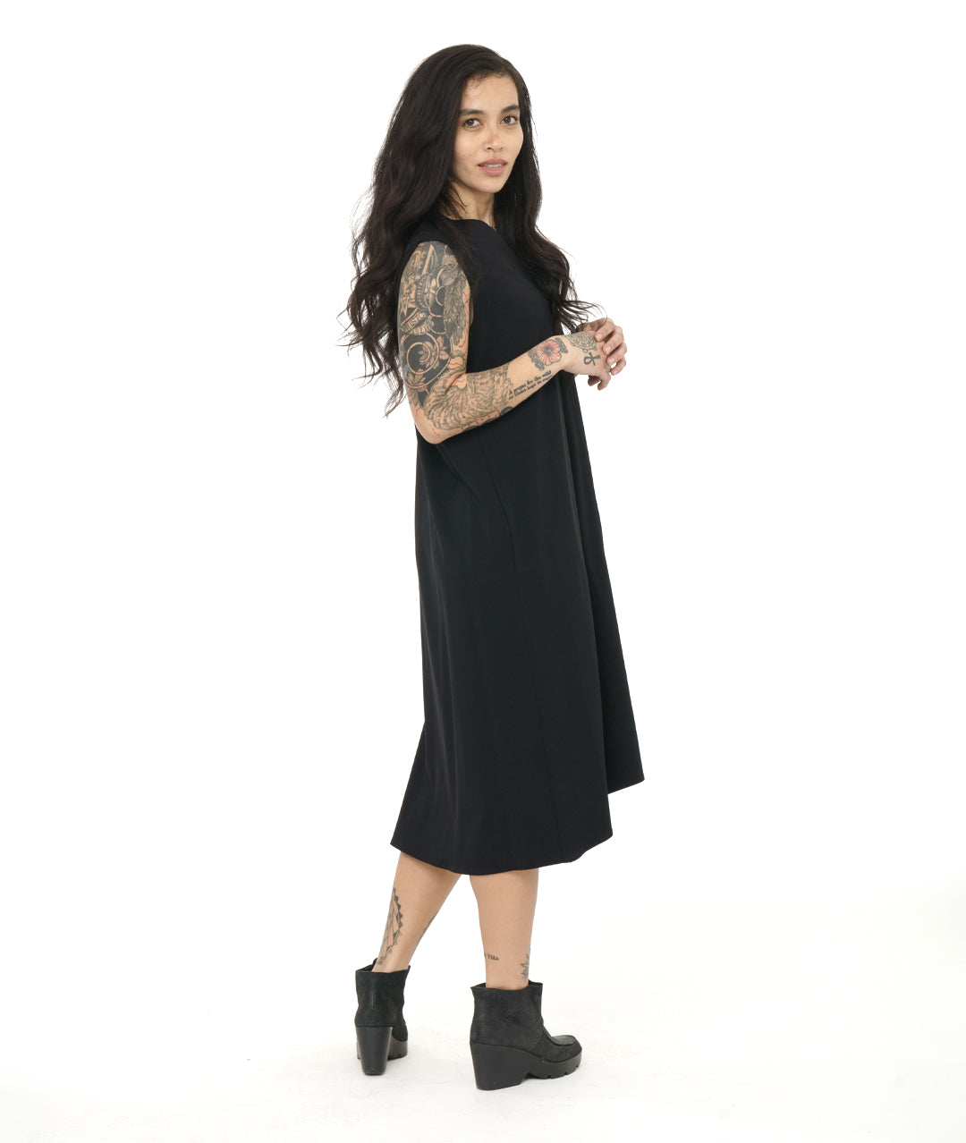model in a black sleeveless dress with a v-neck and a center front seam