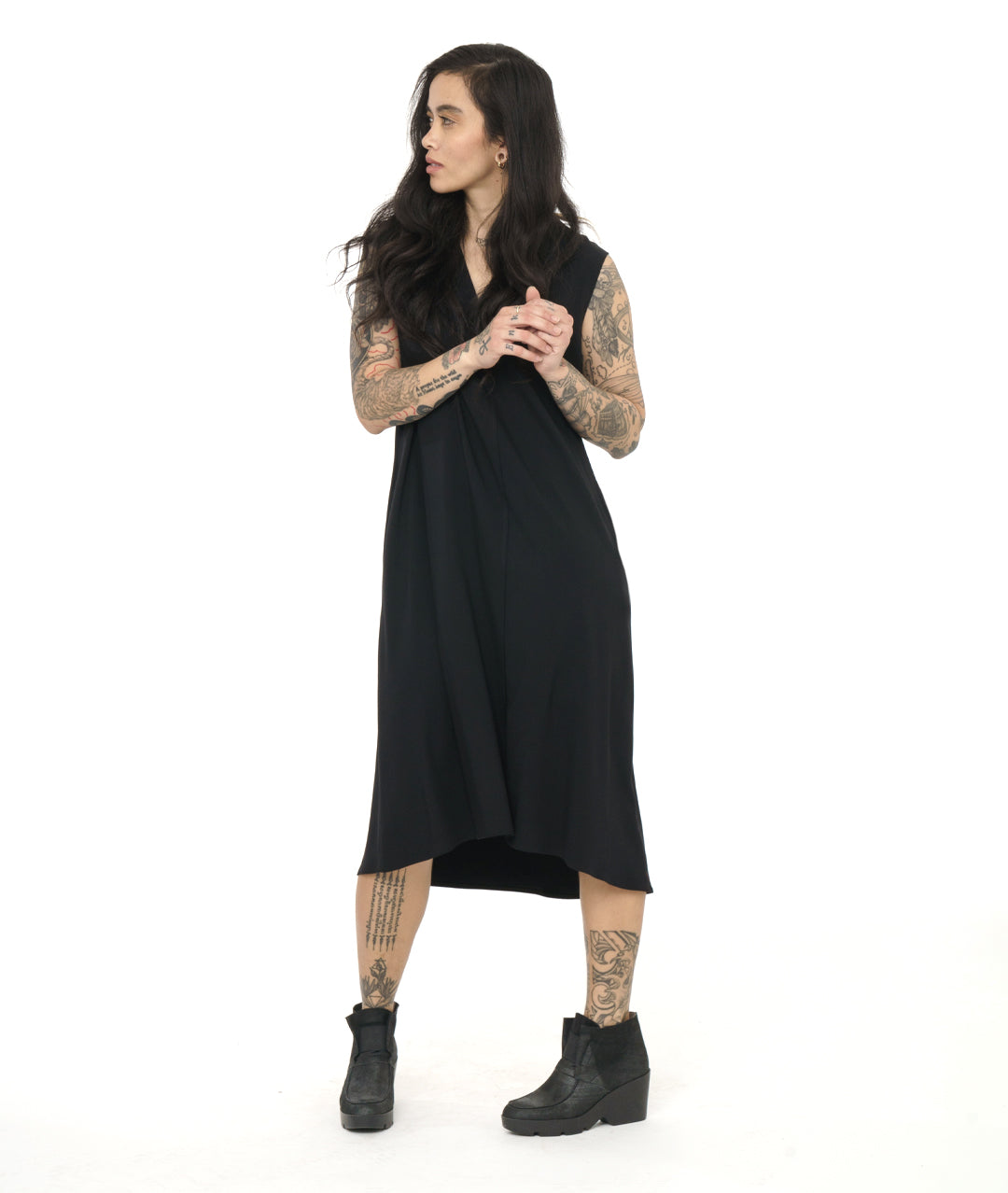 model in a black sleeveless dress with a v-neck and a center front seam