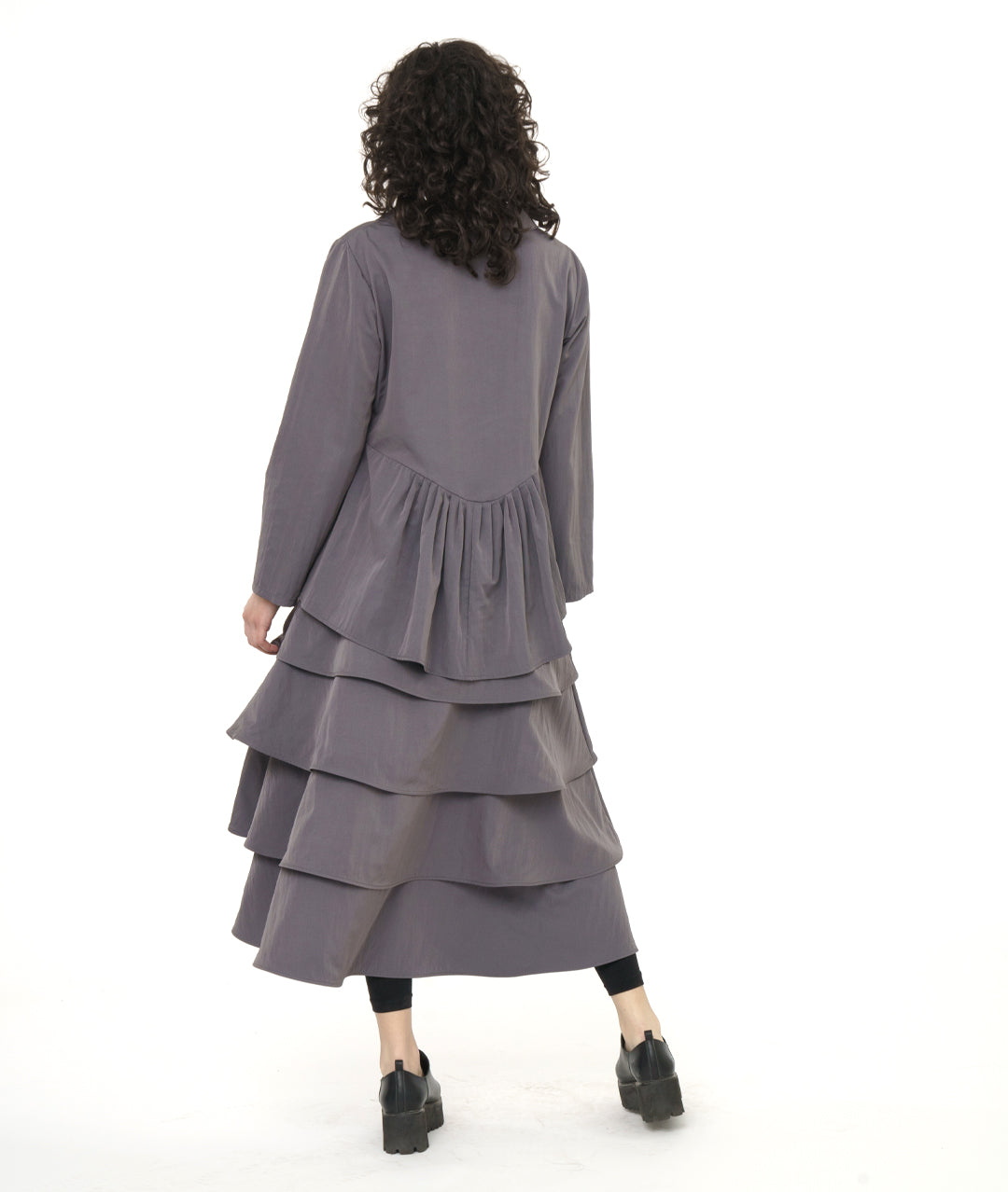 model in a grey tiered skirt with a matching jacket with a high-low peplum in the back