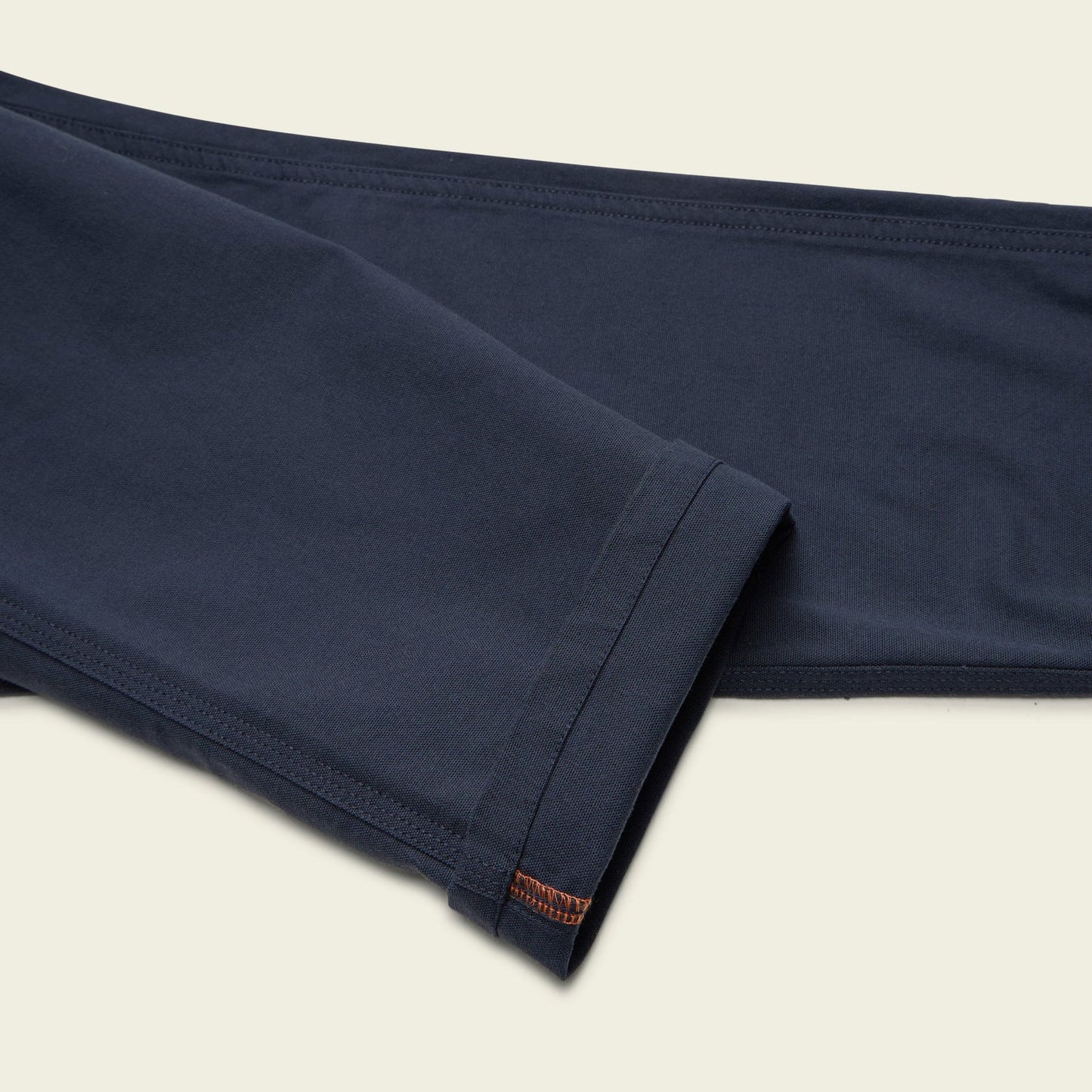 Close up of pant's navy blue fabric on a beige background