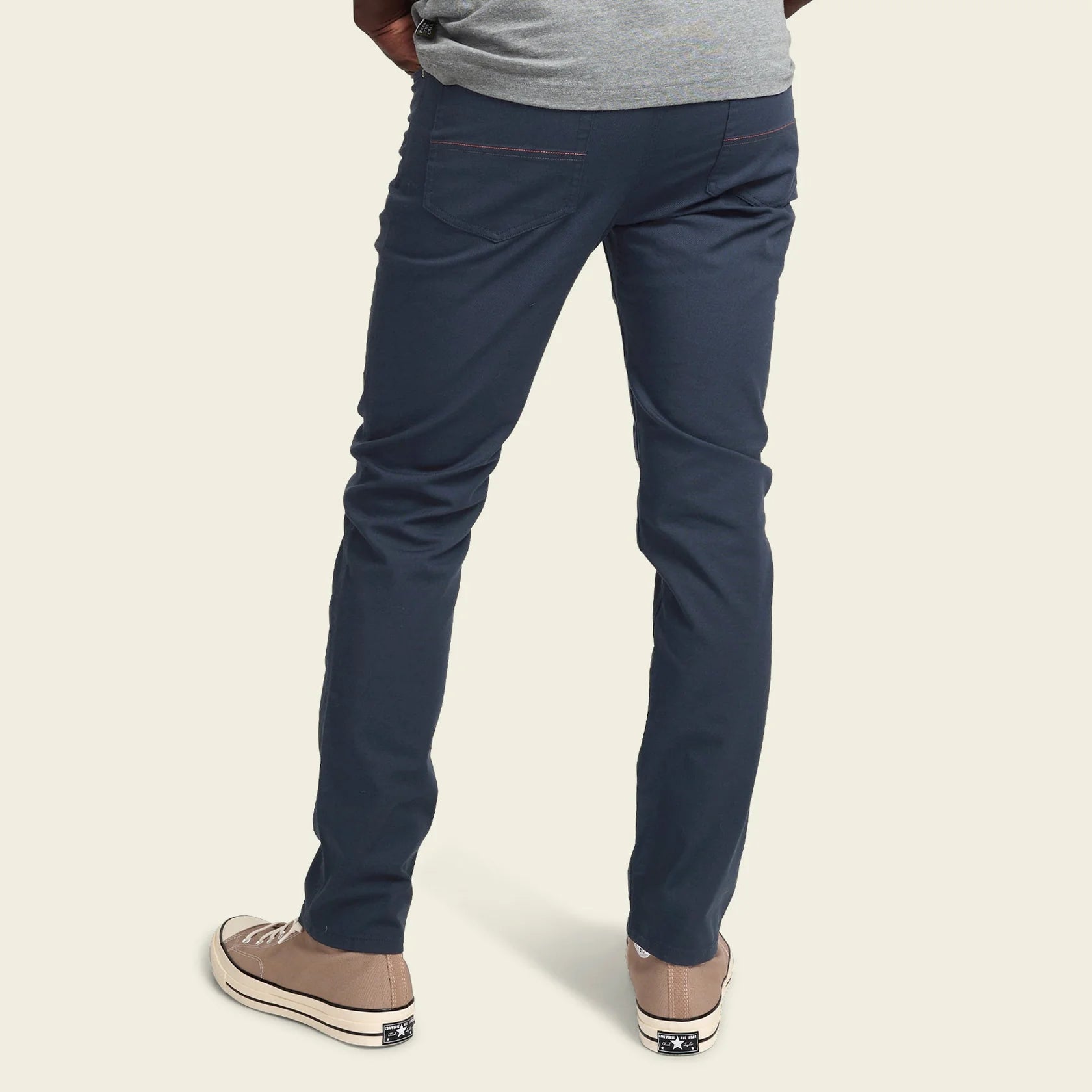 Navy blue pants worn by a person on a beige background