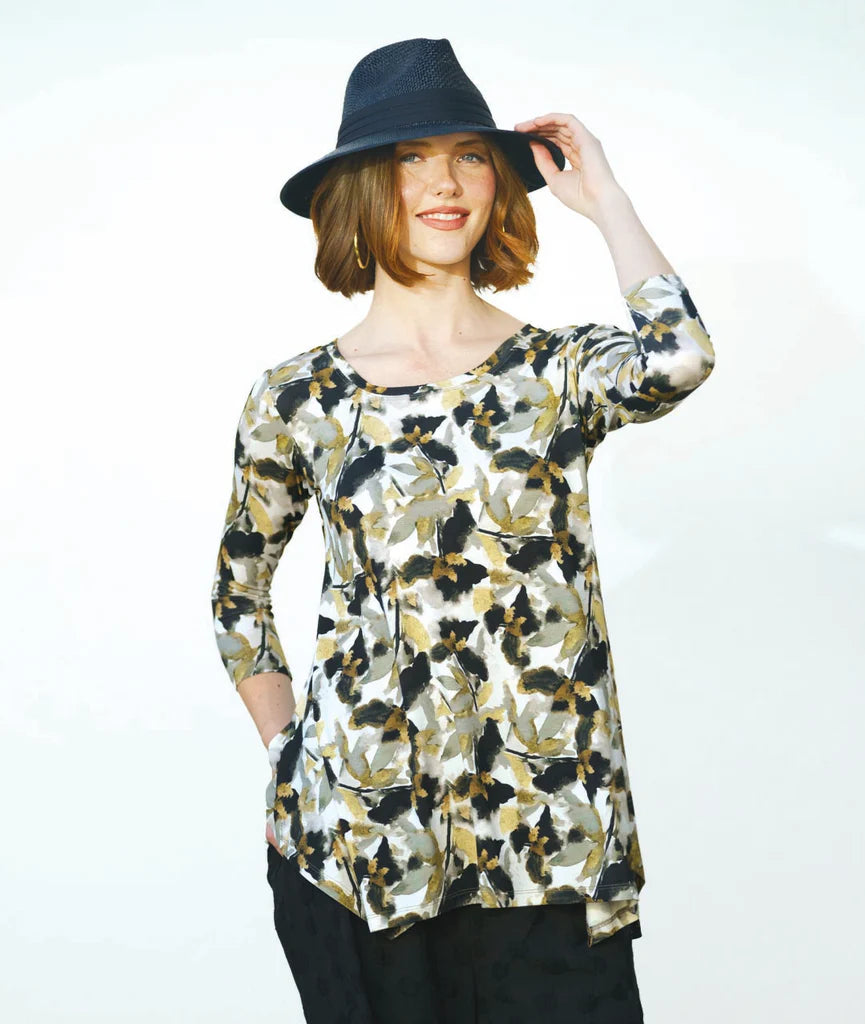 Woman wearing a floral blouse and black hat on a white background