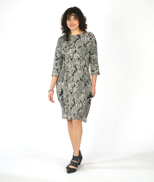 model in a black and white lace knit dress with 3/4 sleeves, pockets and shaping darts at the waist