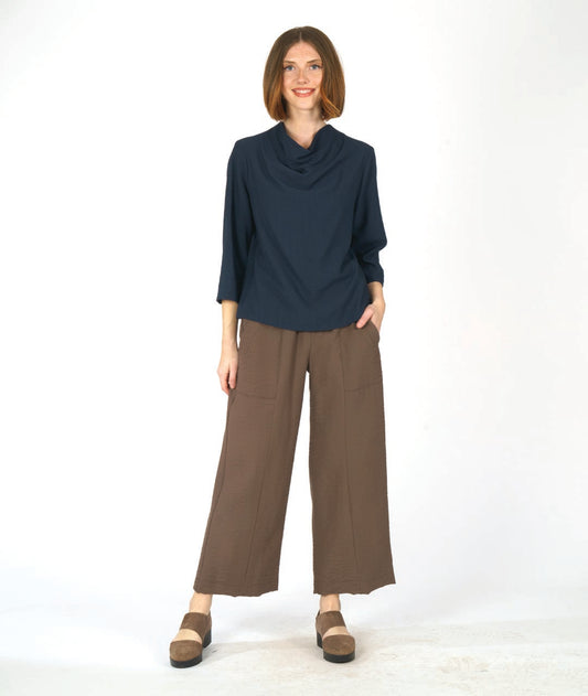 navy pullover top with 3/4 sleeves and a cowl neck, worn with a wide leg brown pant