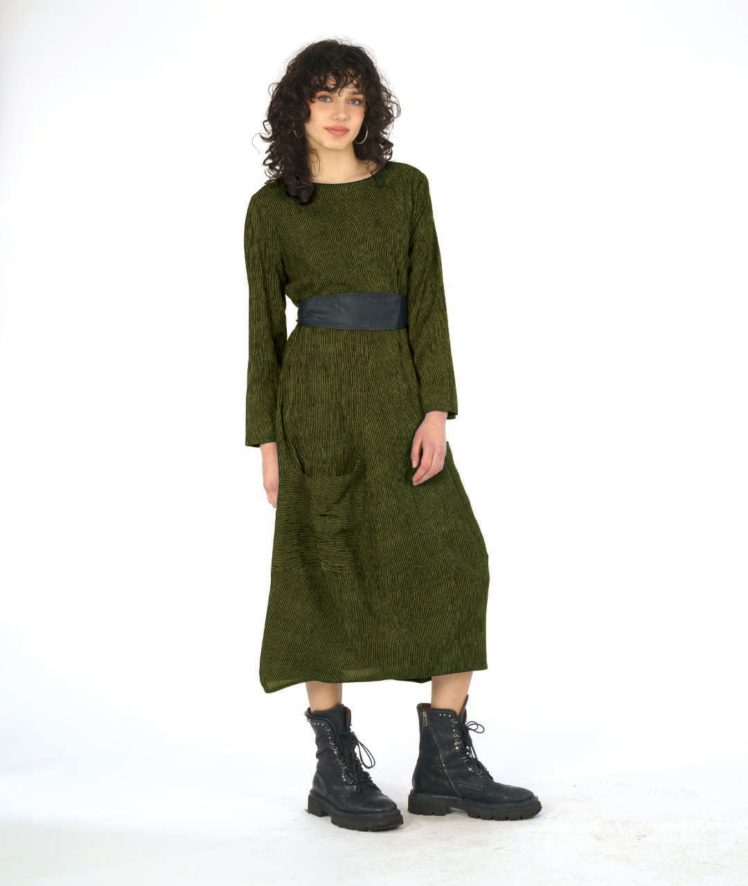 model in a black and green dress with contrasting angled panels, oversized pockets, and long sleeves